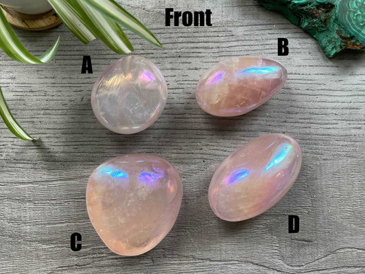 Pictured are various polished aura rose quartz palm stones.