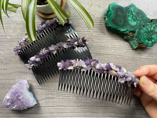 An image of several black hair combs with tumbled amethyst crystals across the top. A slab of malachite and an amethyst cluster sits nearby.