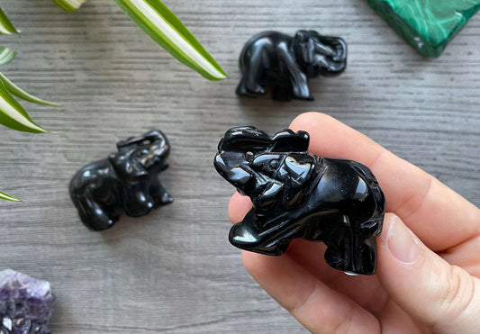 Pictured are various elephants carved out of black obsidian.
