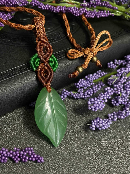 Pictured is a green aventurine cabochon wrapped in macrame thread. A gothic book and flowers are nearby.