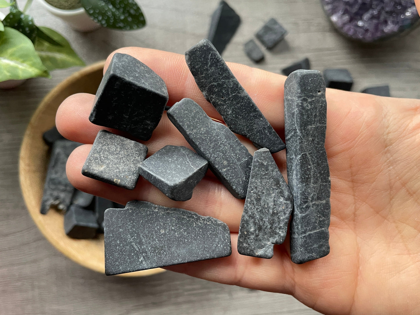 Pictured are various pieces of raw shungite.