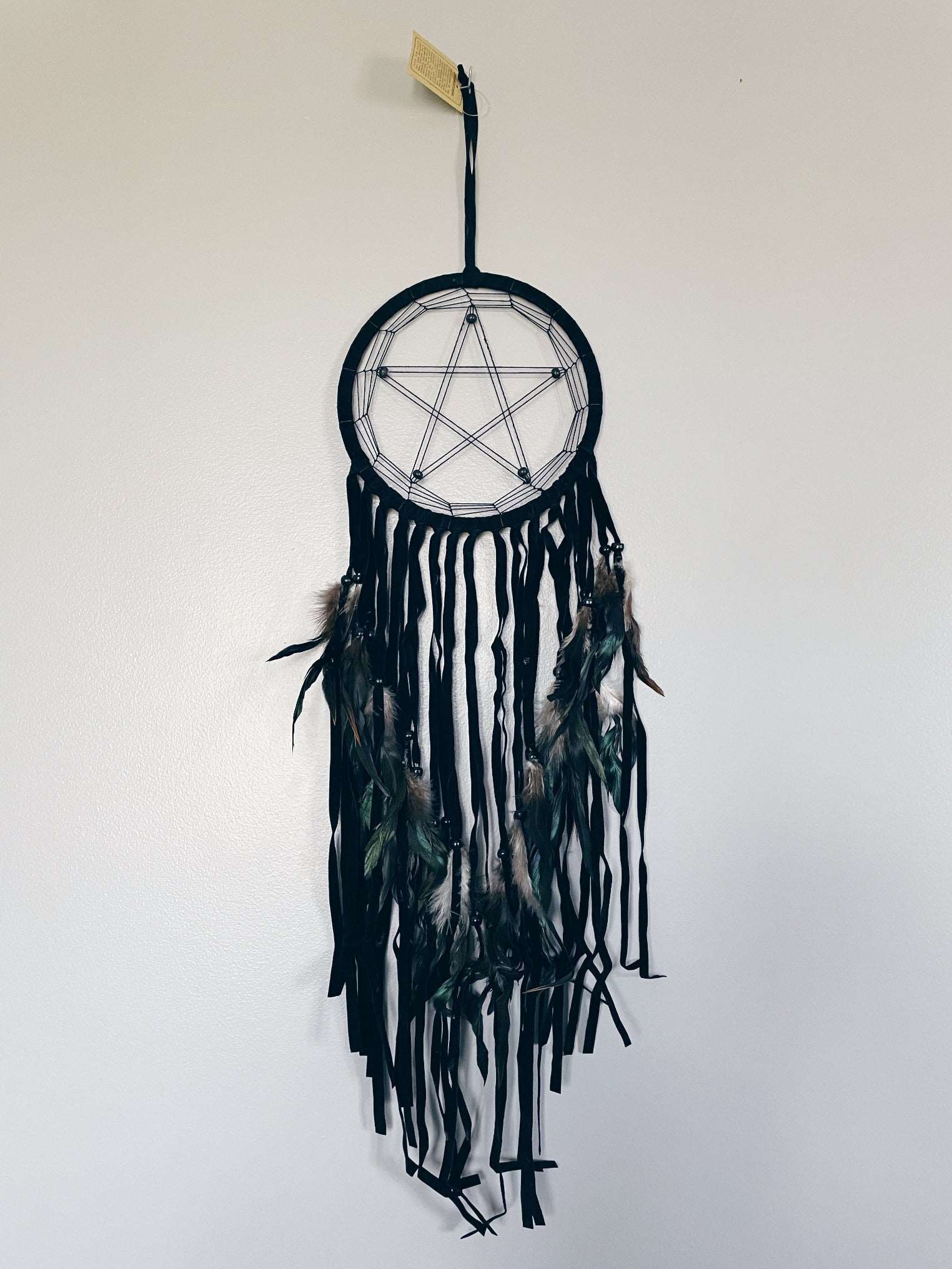 Pictured is a dreamcatcher with a pentagram in the middle.