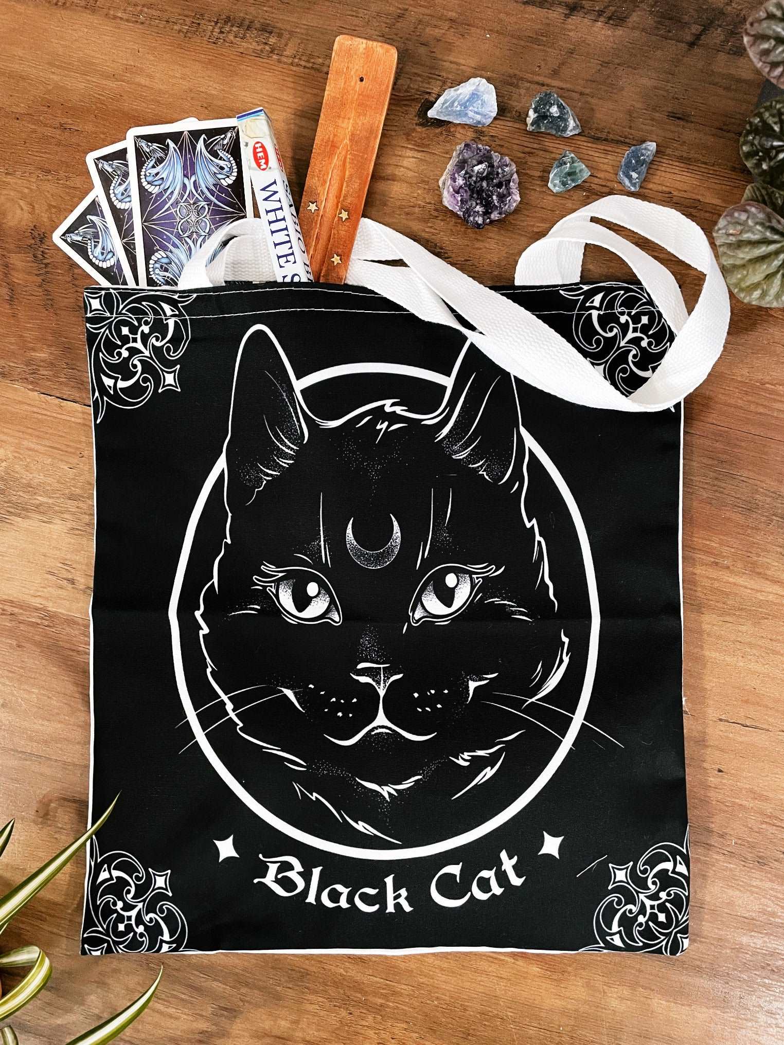 Pictured is a large canvas tote bag featuring an image of a black cat.