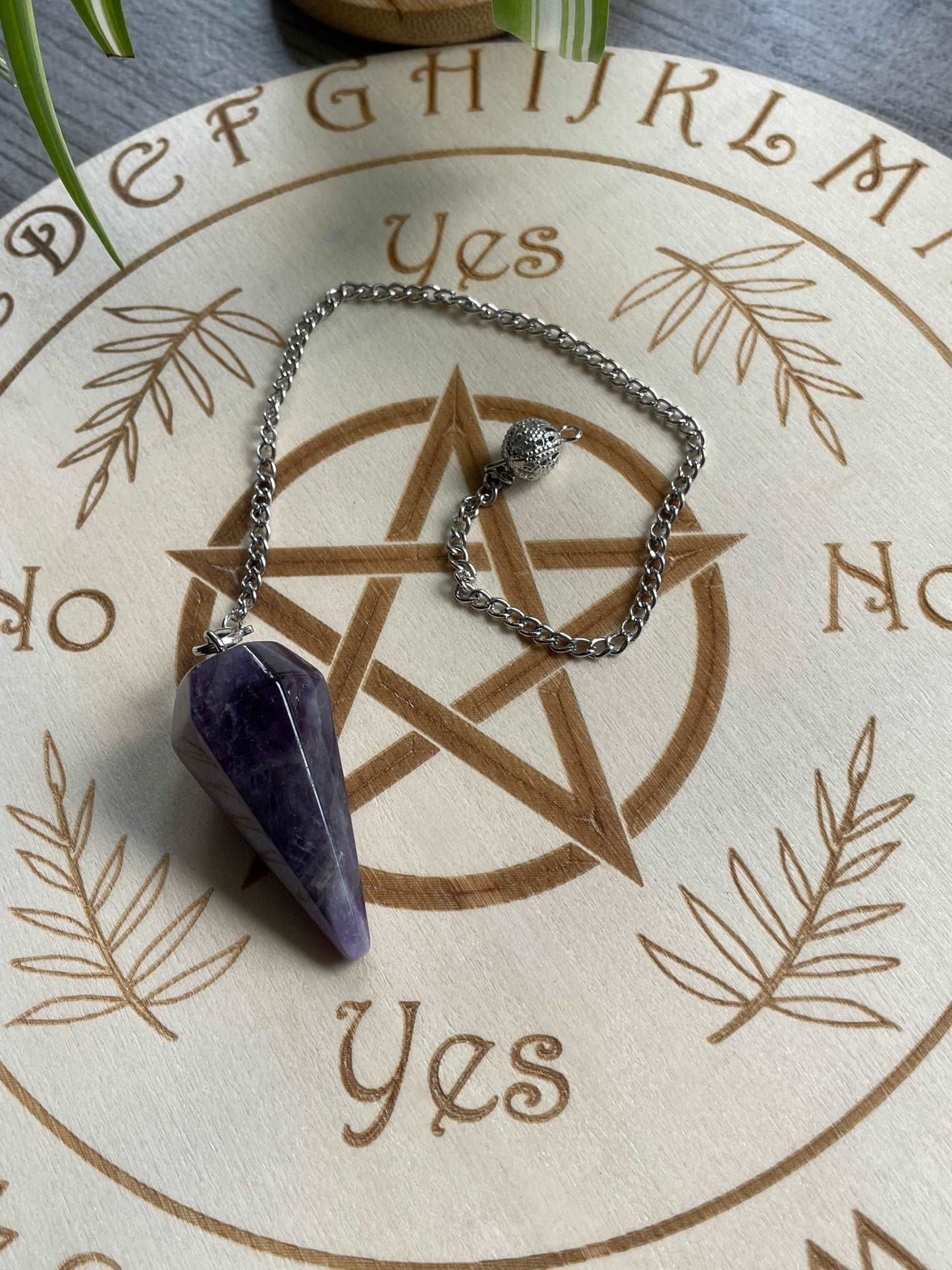 Pictured is an amethyst crystal pendulum.