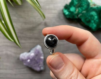 Pictured is a black star sapphire gemstone set in an S925 sterling silver ring.