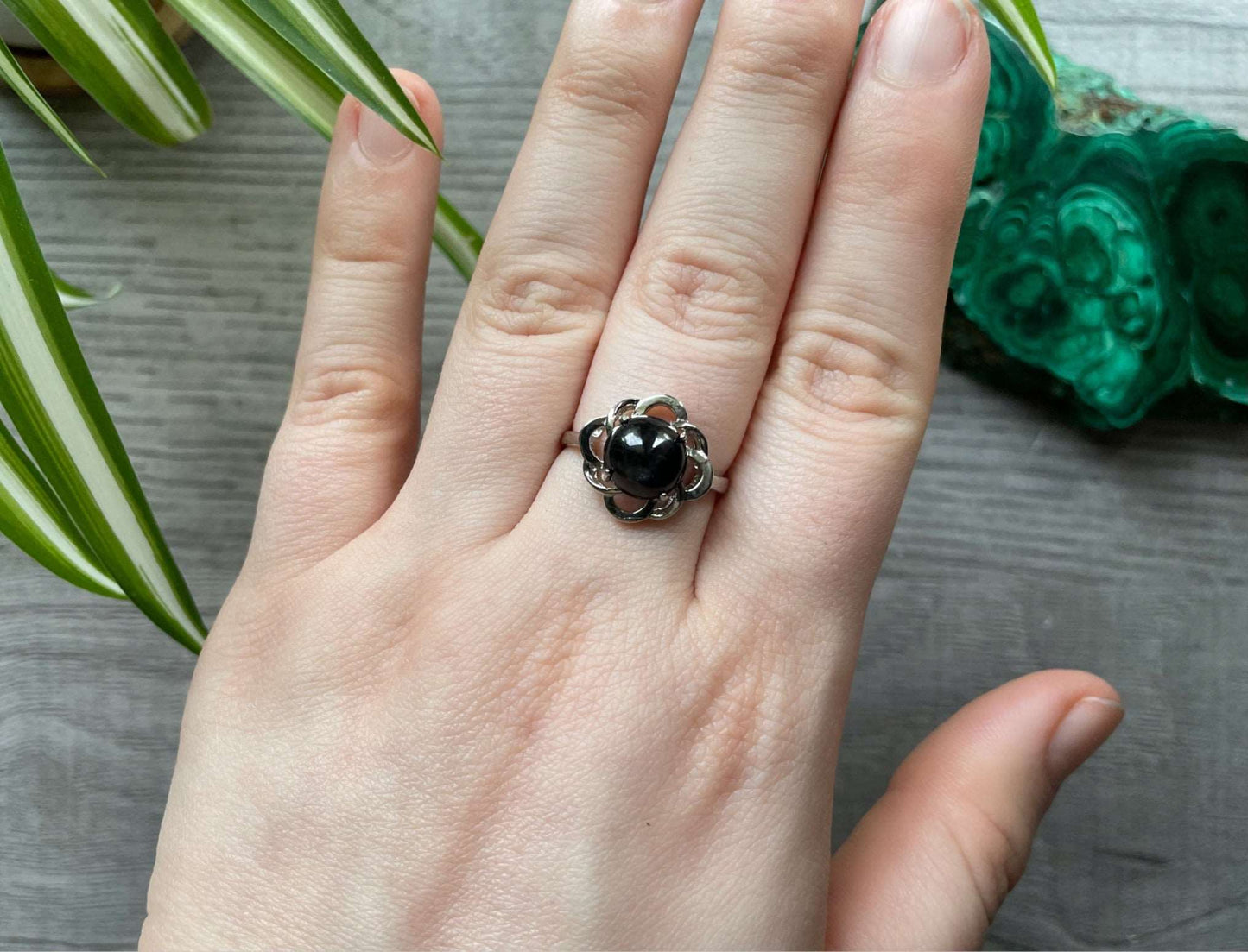 Pictured is a black star sapphire gemstone set in an S925 sterling silver ring.