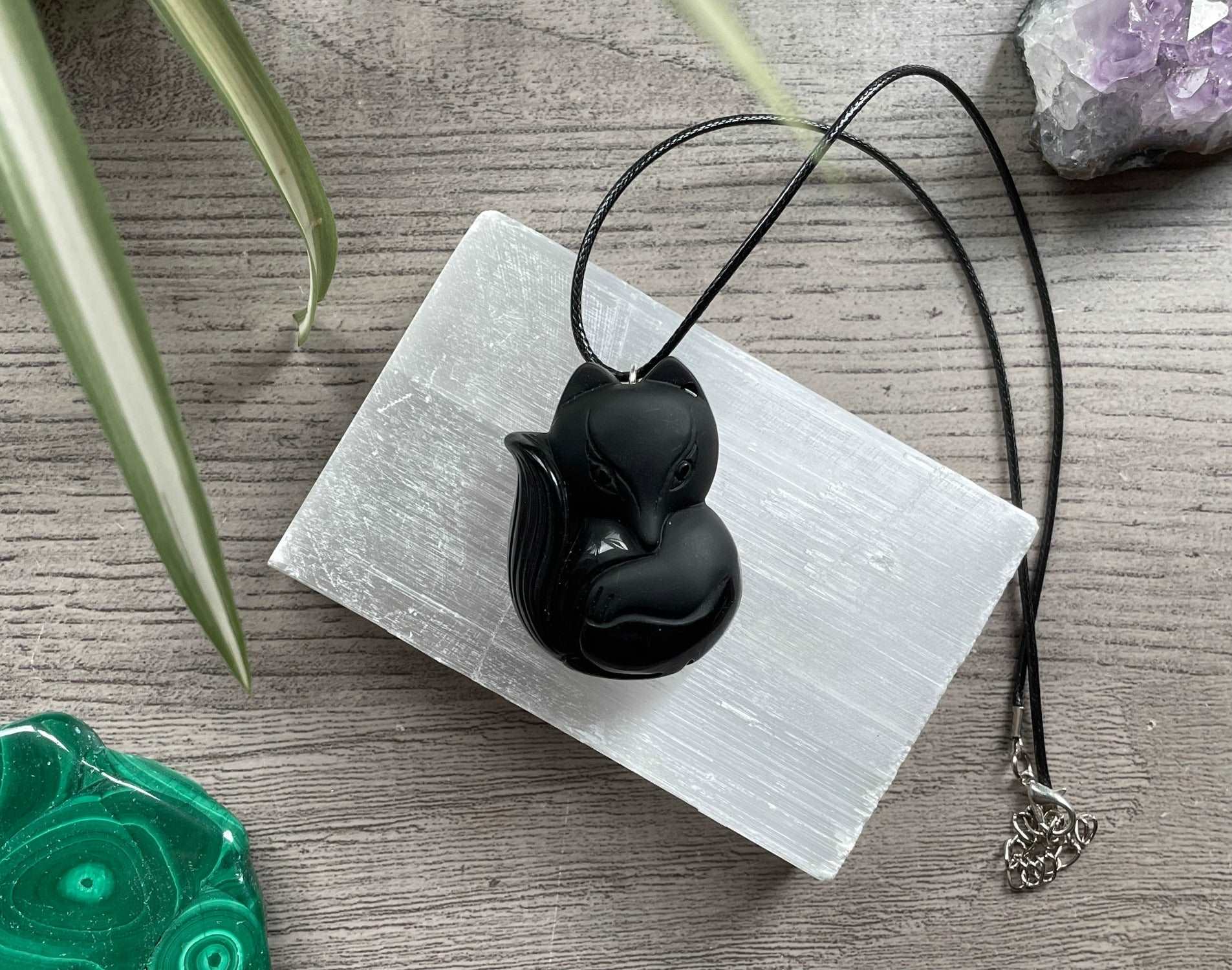 Pictured is a faux obsidian pendant of a fox.