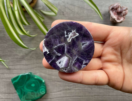 Pictured is an amethyst crystal coin.