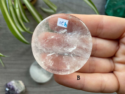 Pictured is a clear quartz crystal coin.