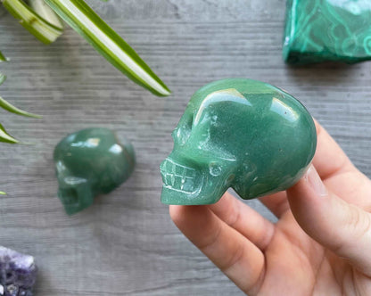 Pictured are various small skulls carved out of green aventurine.