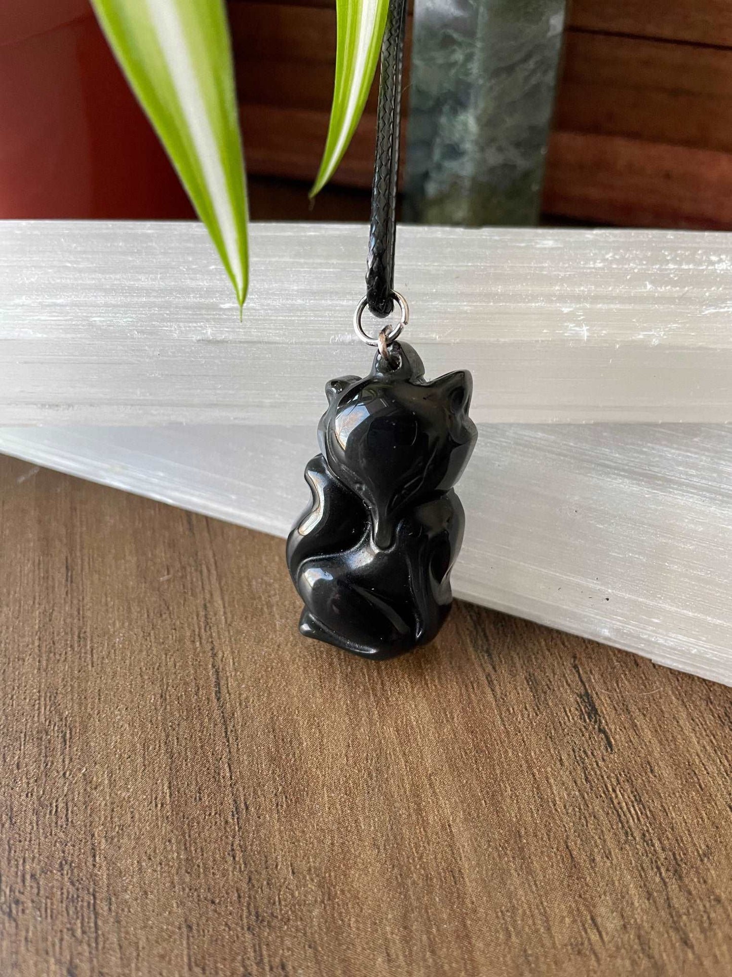 Pictured is a necklace pendant of a fox carved out of black obsidian.