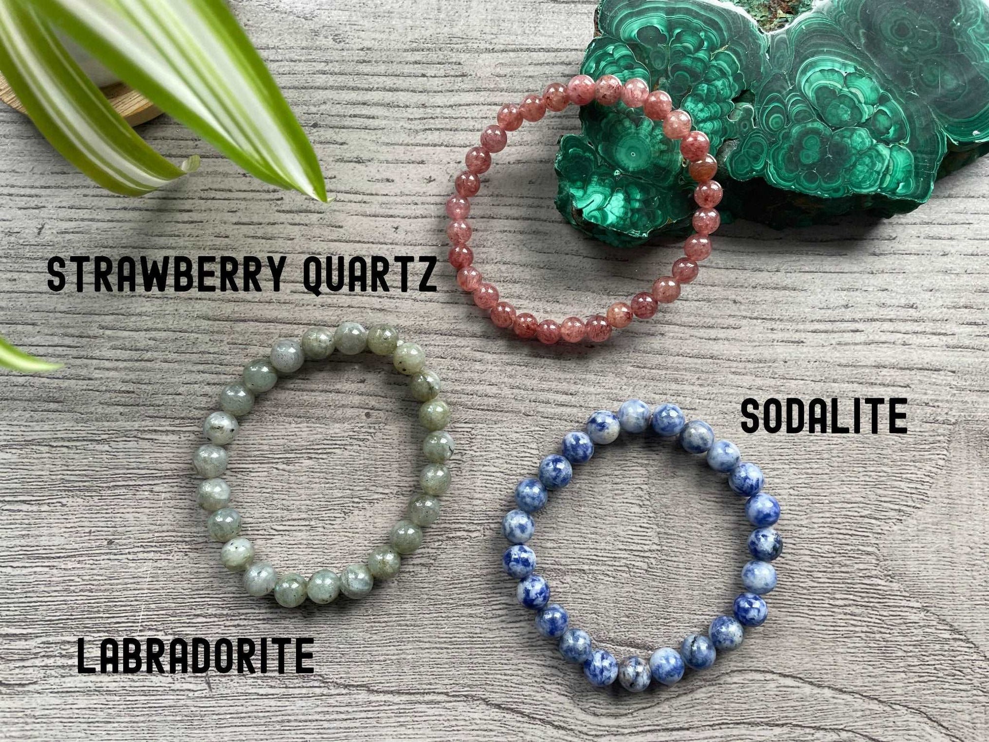 Pictured is a strawberry quartz bead bracelet, a labradorite bead bracelet, and a sodalite bead bracelet.