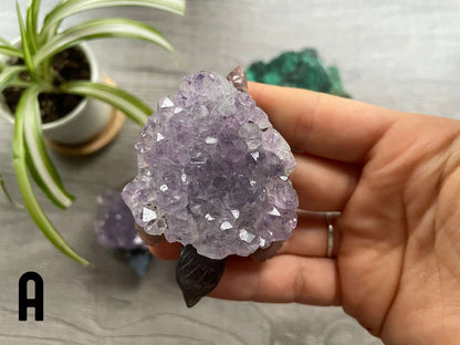 A grey agate turtle carving with purple amethyst crystals on its shell.