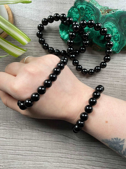 Pictured is a black obsidian bead bracelet.