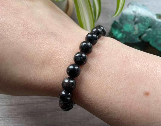 Pictured is an arfvedsonite bead bracelet.