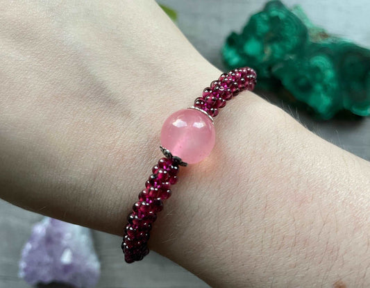 Pictured is a garnet bead bracelet with a large rose quartz bead in the center.
