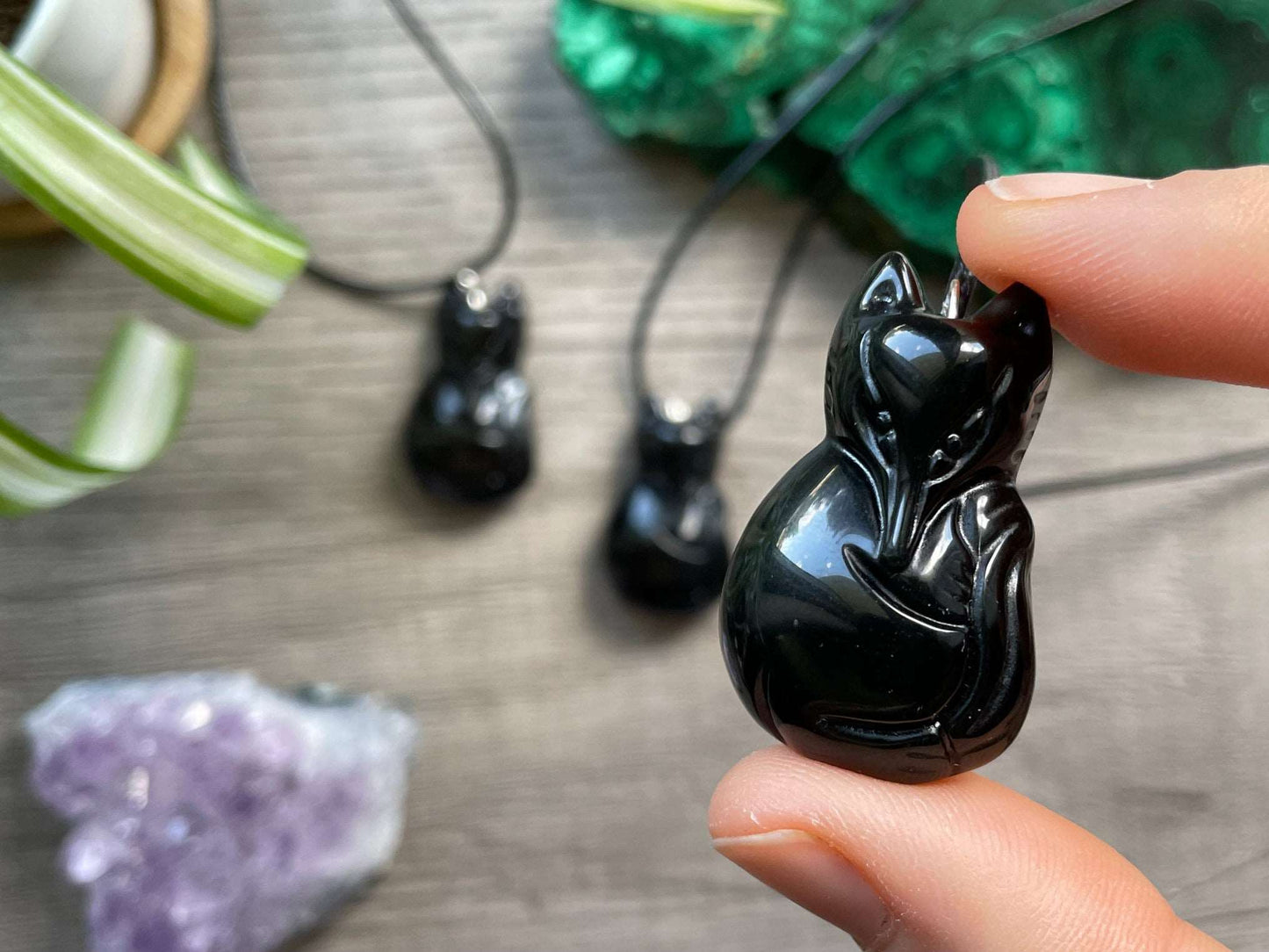 Pictured is a necklace pendant of a fox carved out of black obsidian.