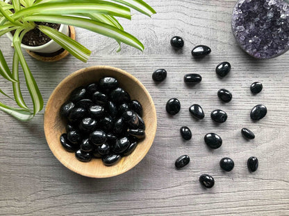 Pictured are various black tourmaline tumbled stones.