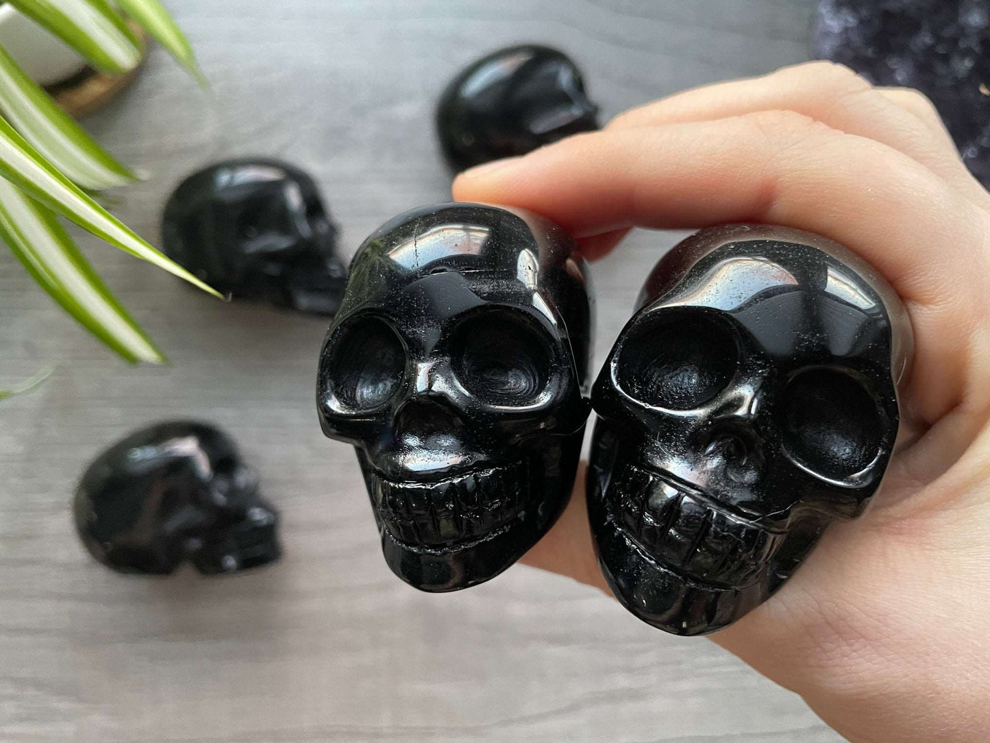 Pictured are various small skulls carved out of black obsidian.