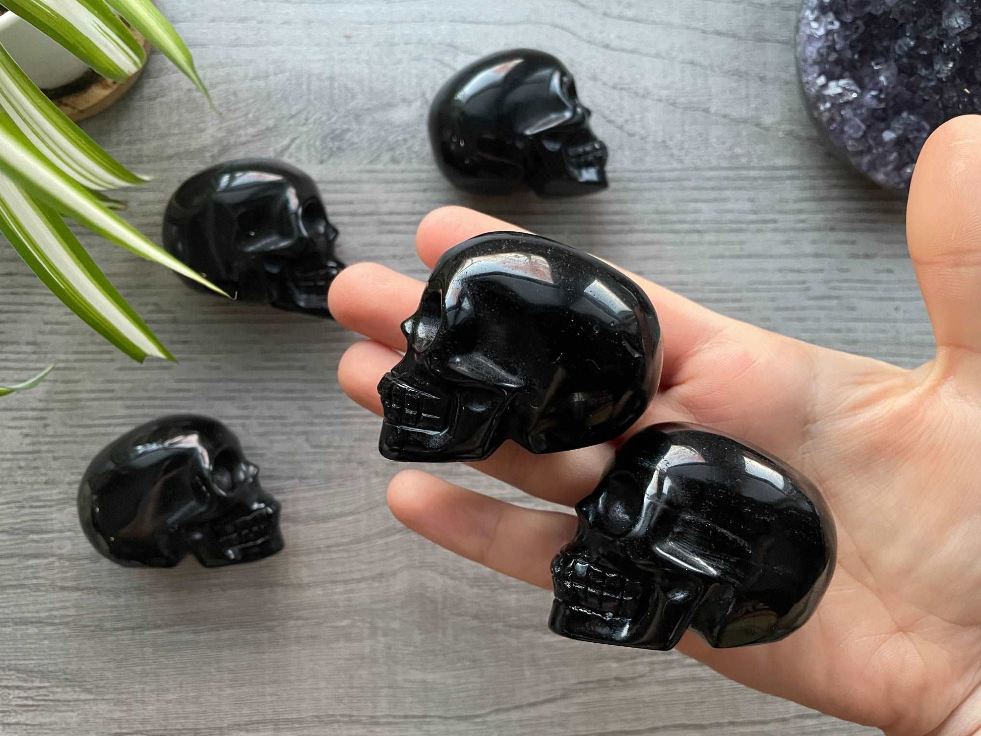 Pictured are various small skulls carved out of black obsidian.