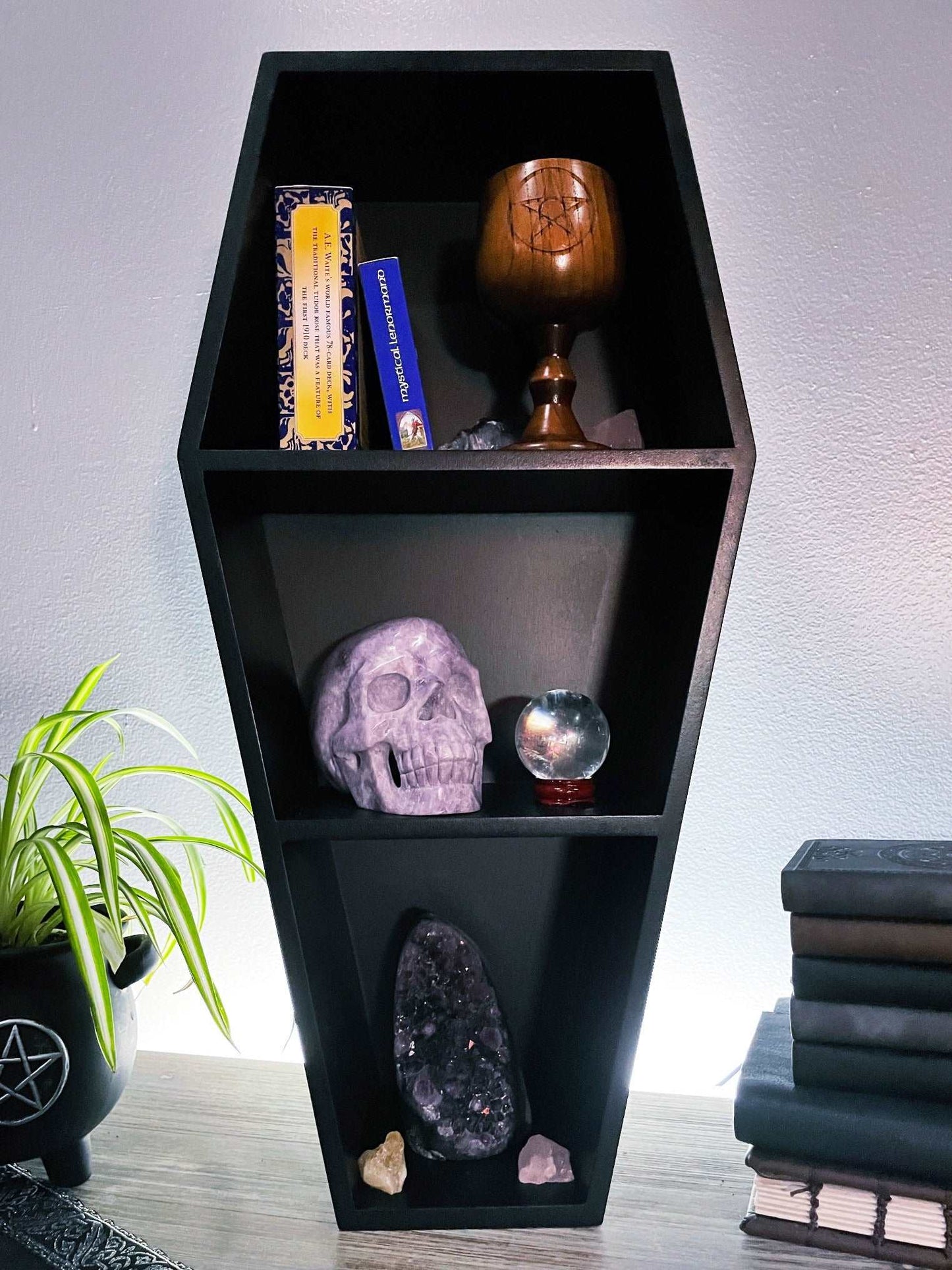Pictured is a shelving unit shaped like a black coffin.