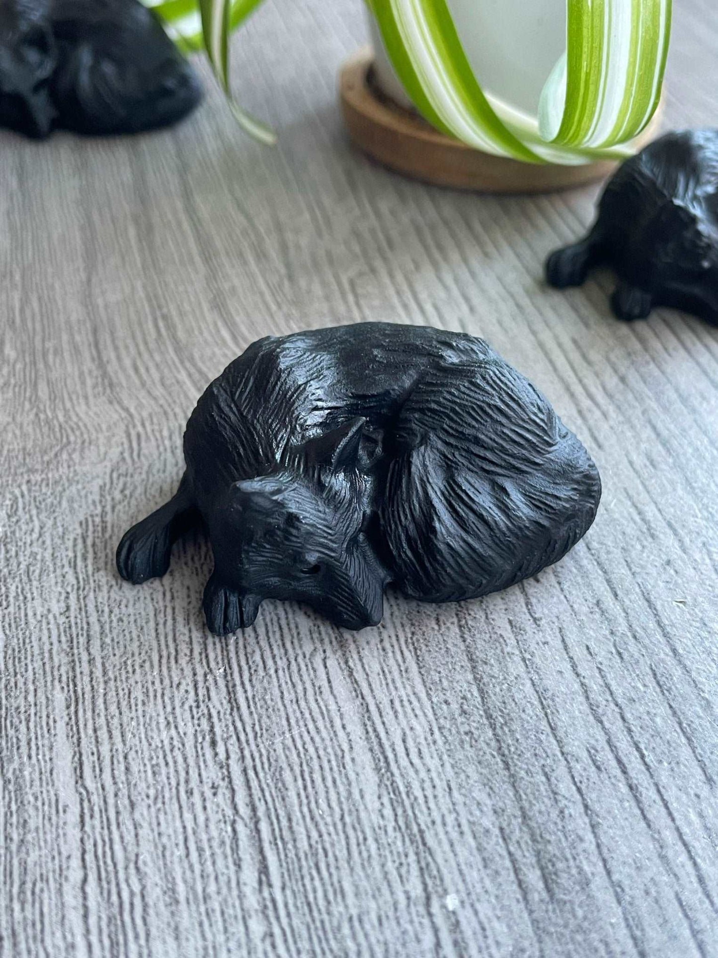 Pictured is a sleeping wolf carved out of black obsidian. Pictured is a sleeping fox carved out of black obsidian.