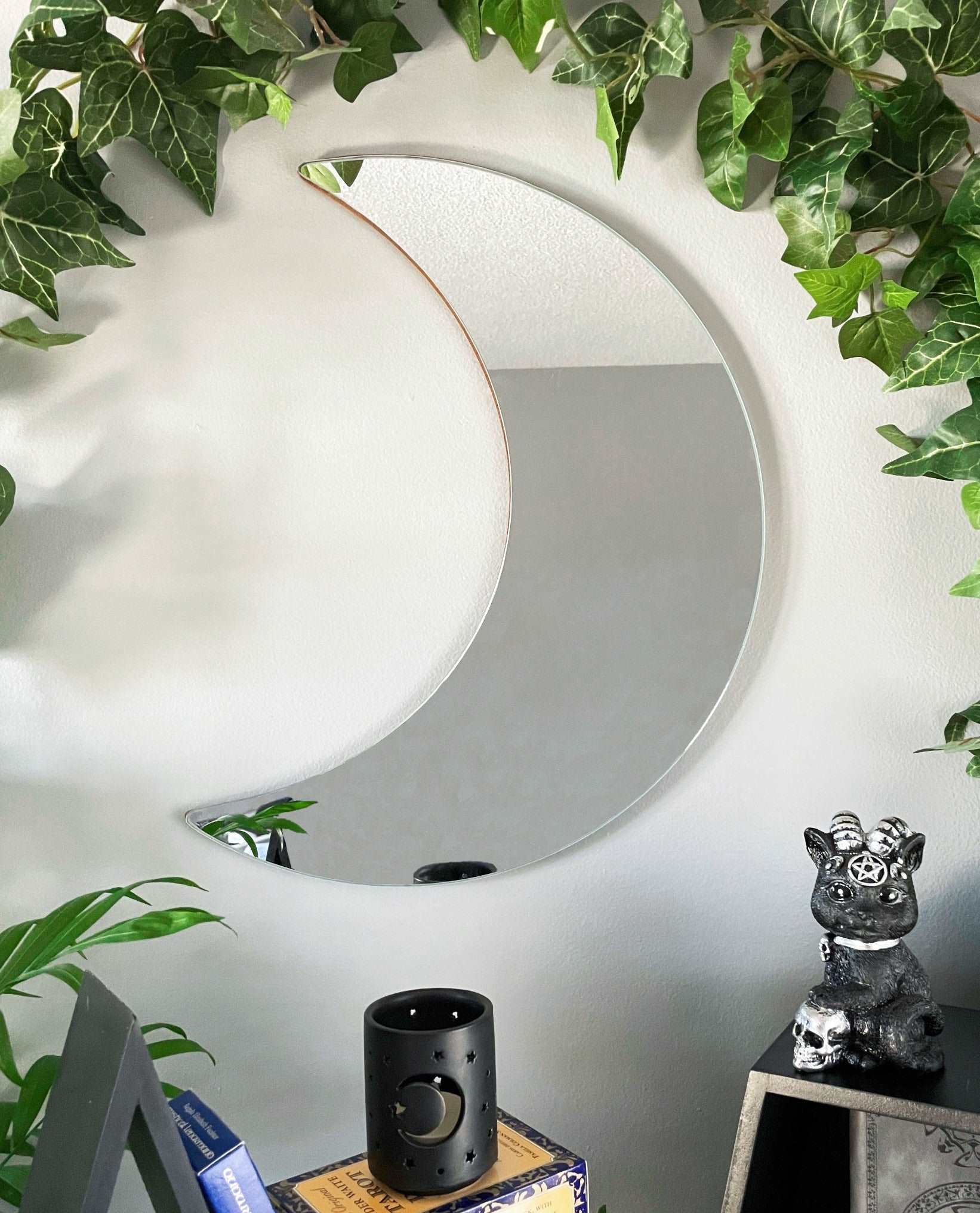 Pictured is a mirror shaped like a crescent moon.