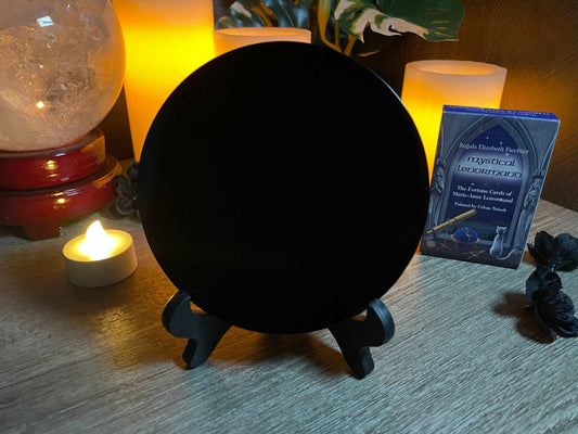 Pictured is a scrying mirror on a stand. The scrying mirror is carved out of black obsidian.