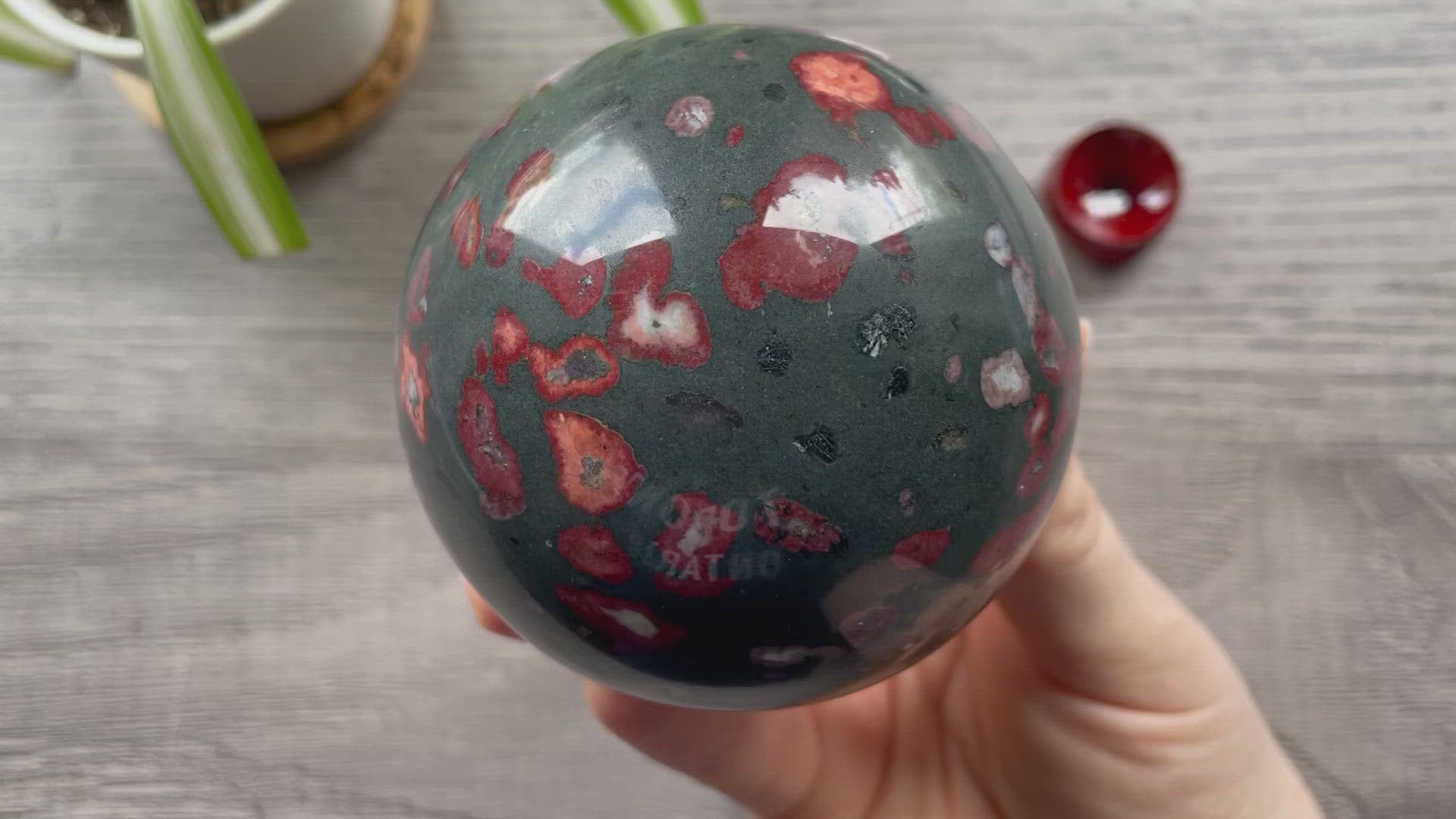 Pictured is a sphere carved out of plumite / poppy jasper.