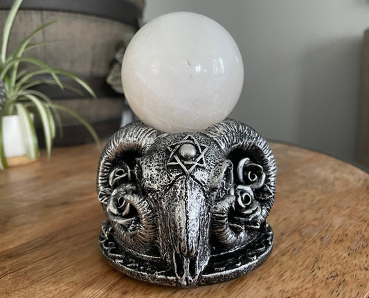 Pictured is a sphere stand in the shape of goat skulls ram skulls.
