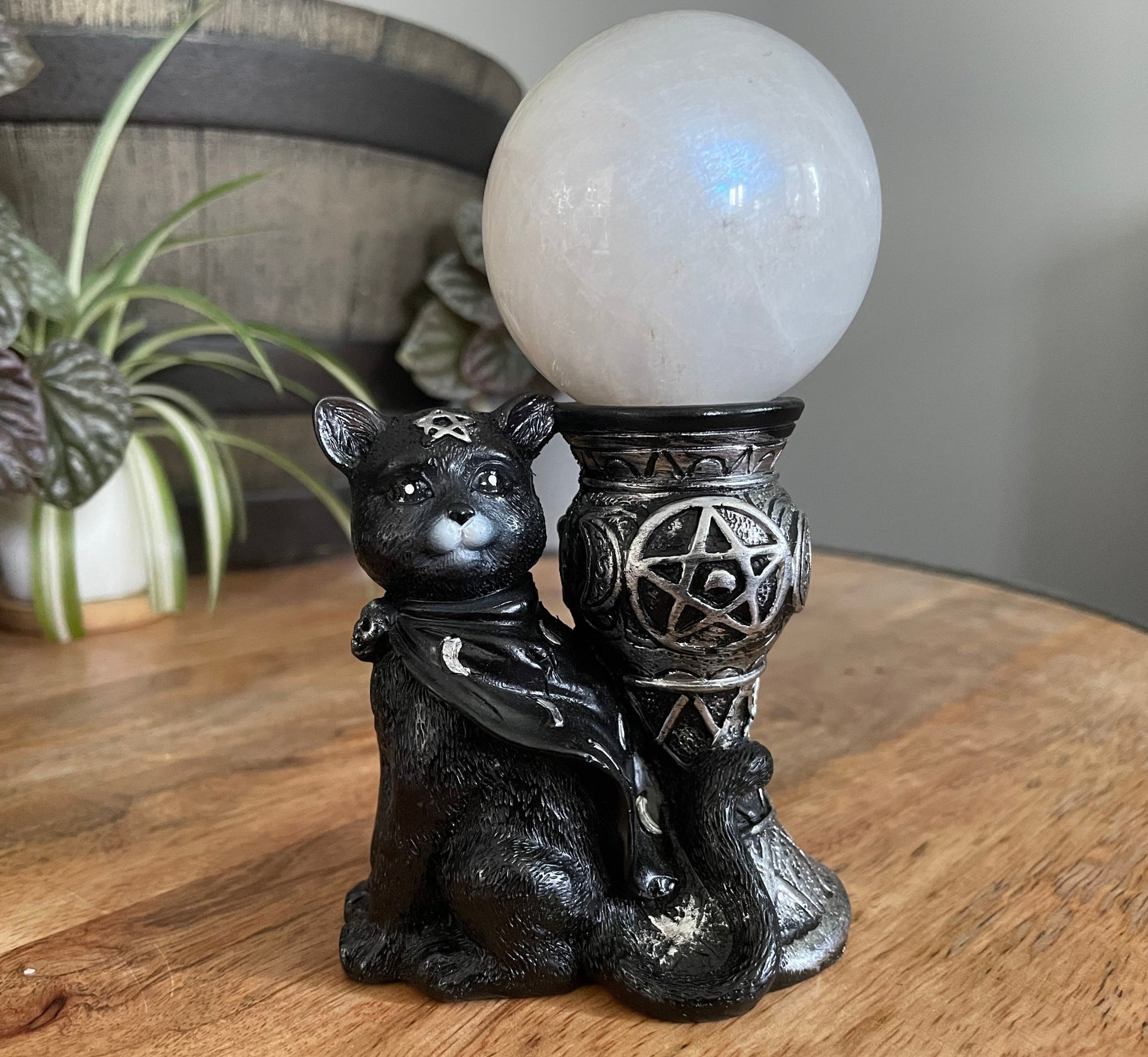 Pictured is a sphere stand with a black magic cat beside it.