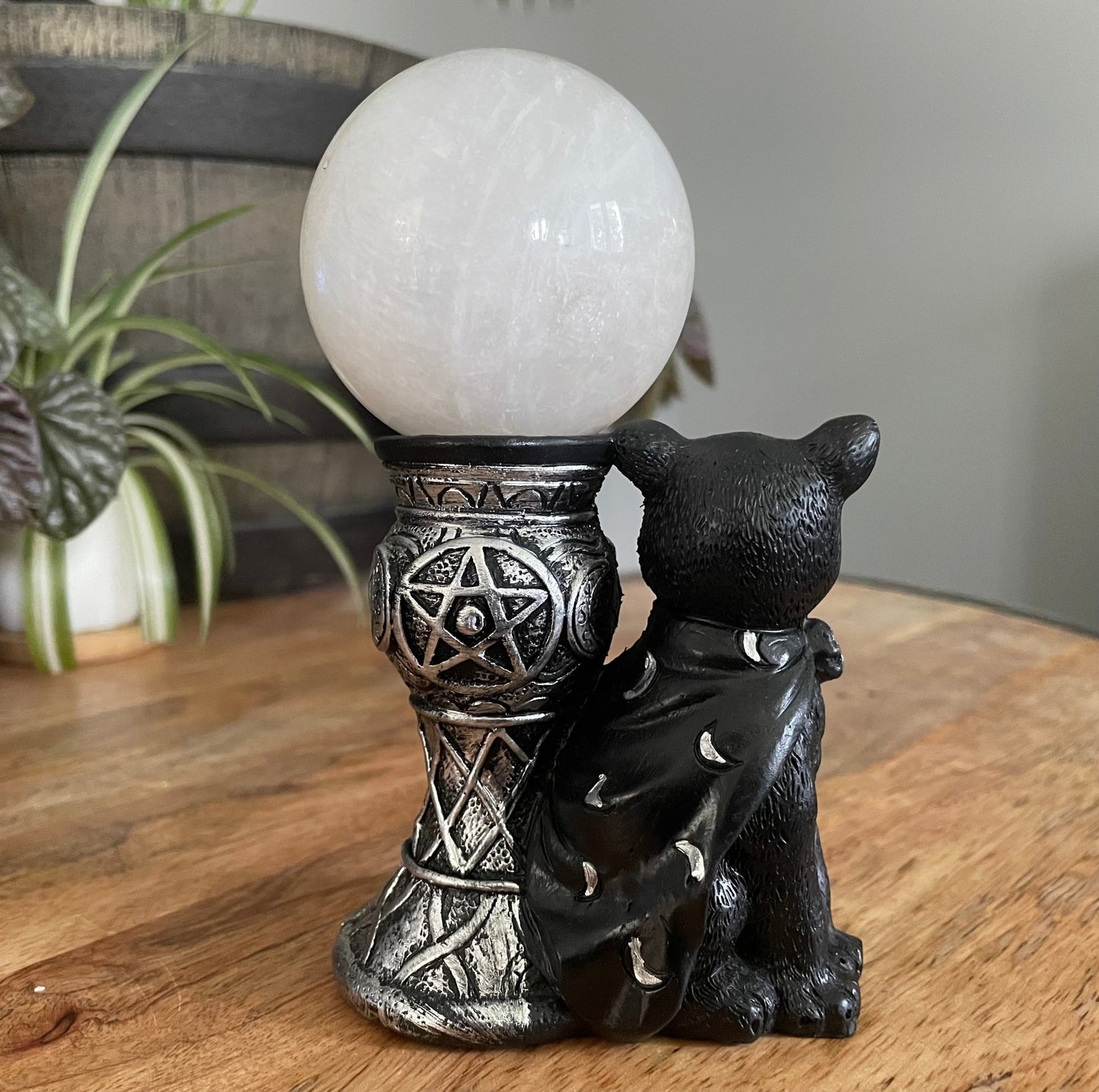 Pictured is a sphere stand with a black magic cat beside it.