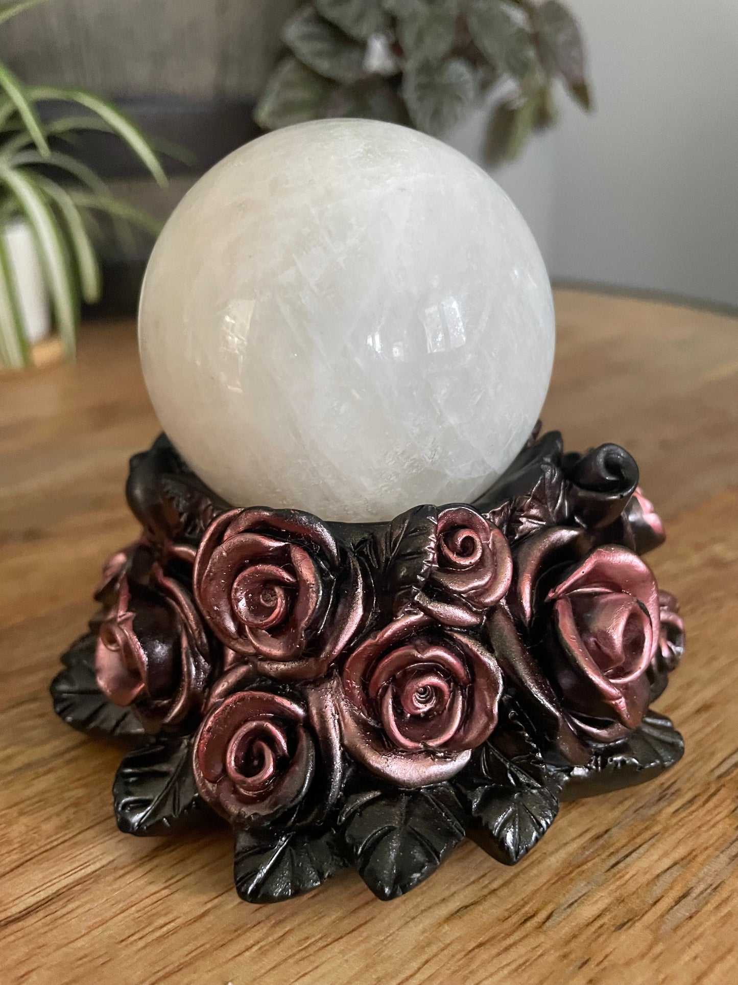 Pictured is a sphere stand in the shape of a bed of rose gold roses.