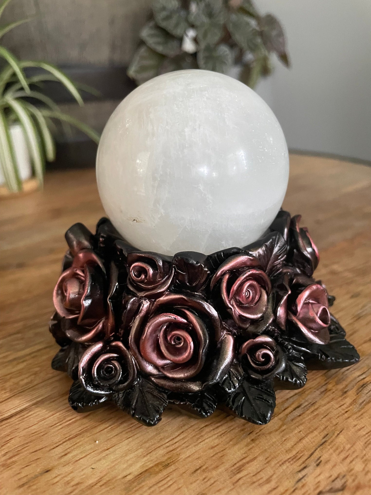 Pictured is a sphere stand in the shape of a bed of rose gold roses.