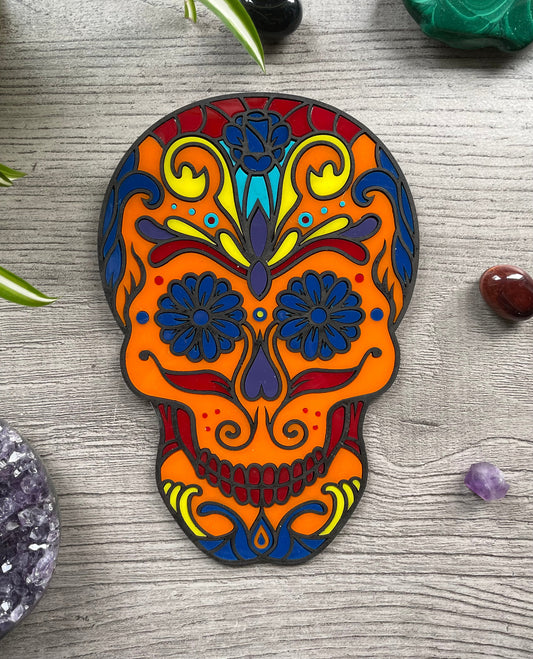Pictured is a faux stained glass sugar skull made out of wood and acrylic.