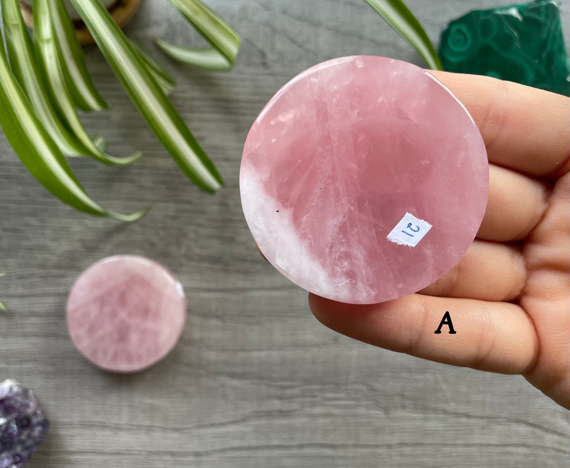 Pictured is a rose quartz crystal coin.