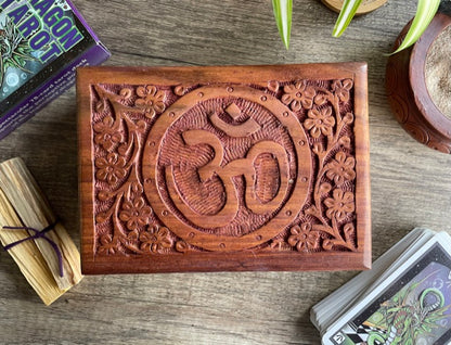 Pictured is hand-carved wood box with the "OM" symbol in the middle.