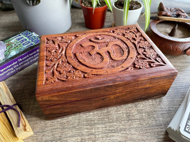 Pictured is hand-carved wood box with the "OM" symbol in the middle.