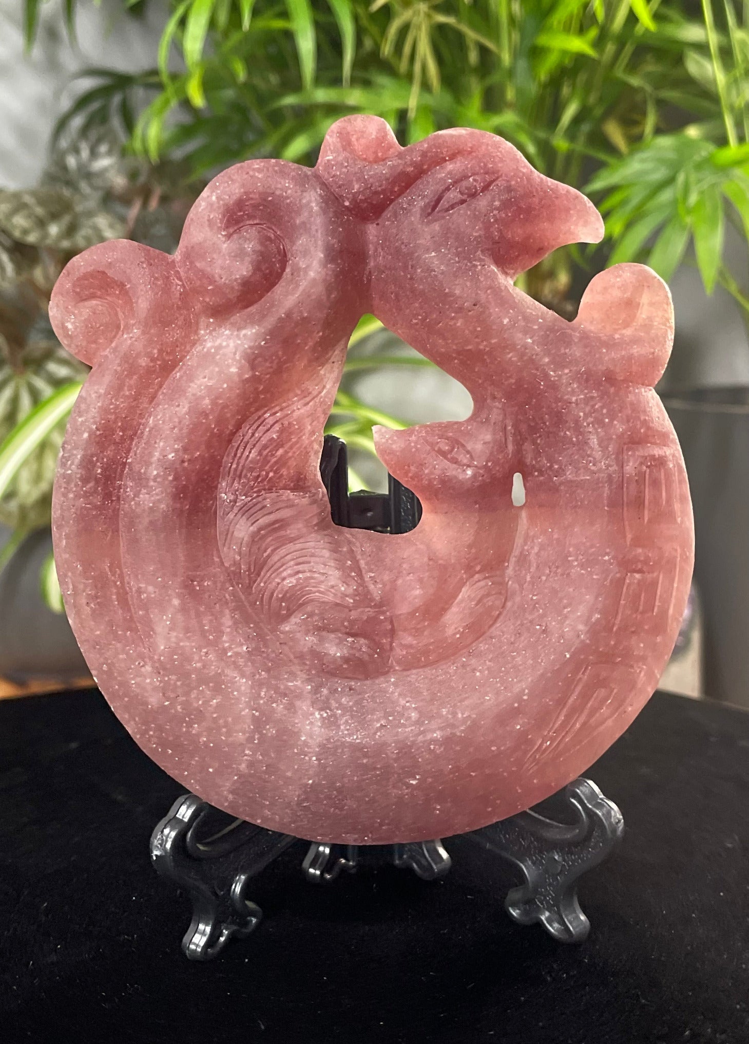 Pictured is a nine-tailed fox sitting on a phoenix carved out of strawberry quartz.