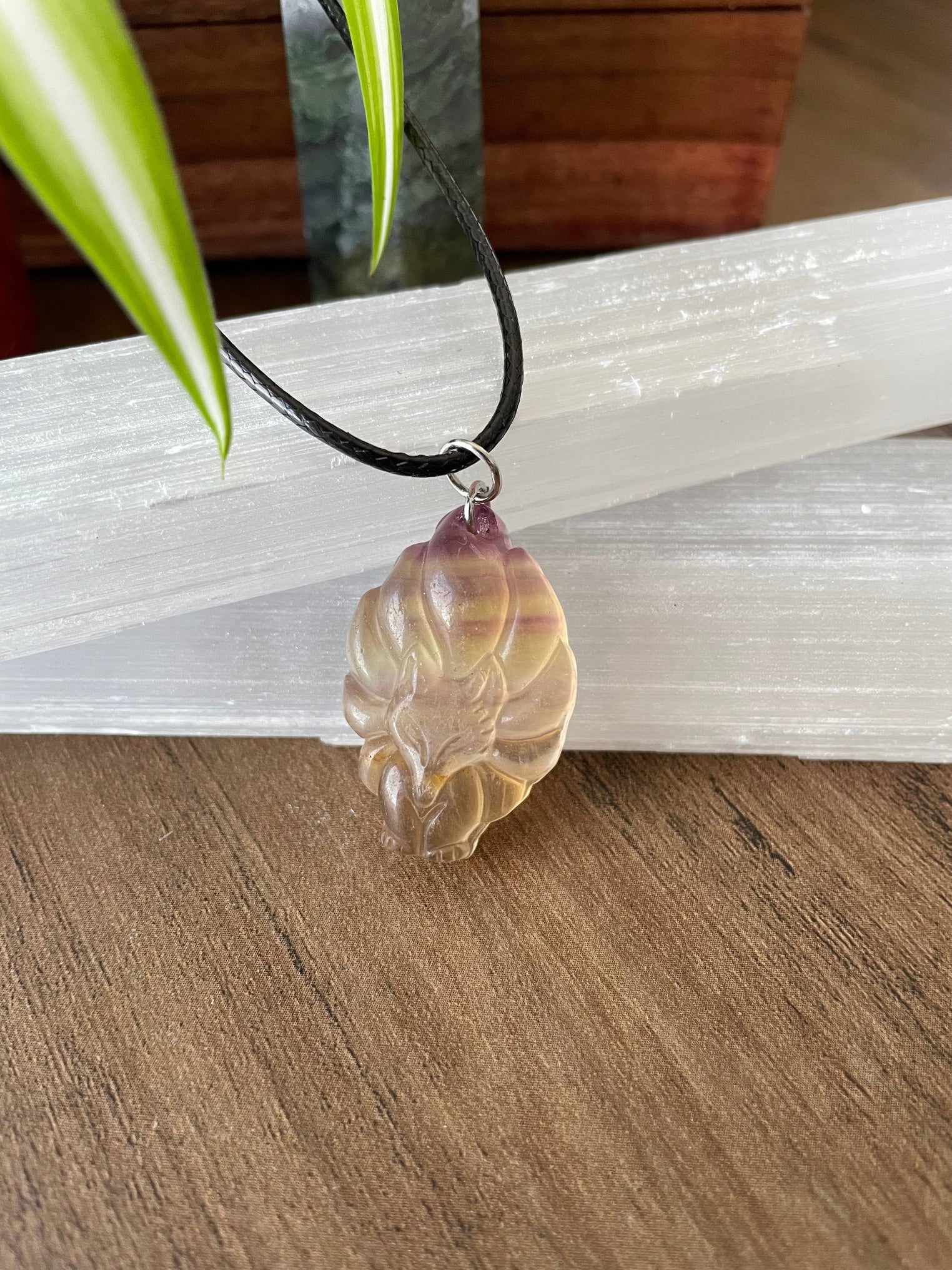 Pictured is a nine-tailed fox yellow fluorite necklace.