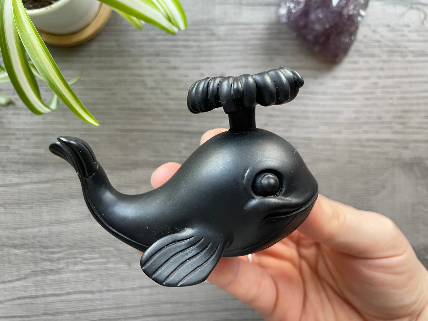Pictured is a sphere stand in the shape of a whale.