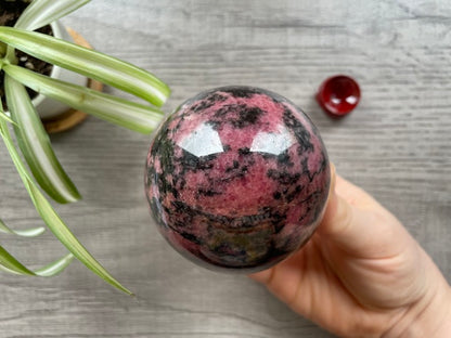 Pictured is a sphere carved out of rhodonite.