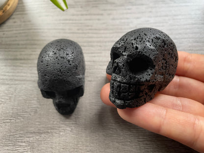 Pictured are various skulls carved out of lava stone or lava rock.