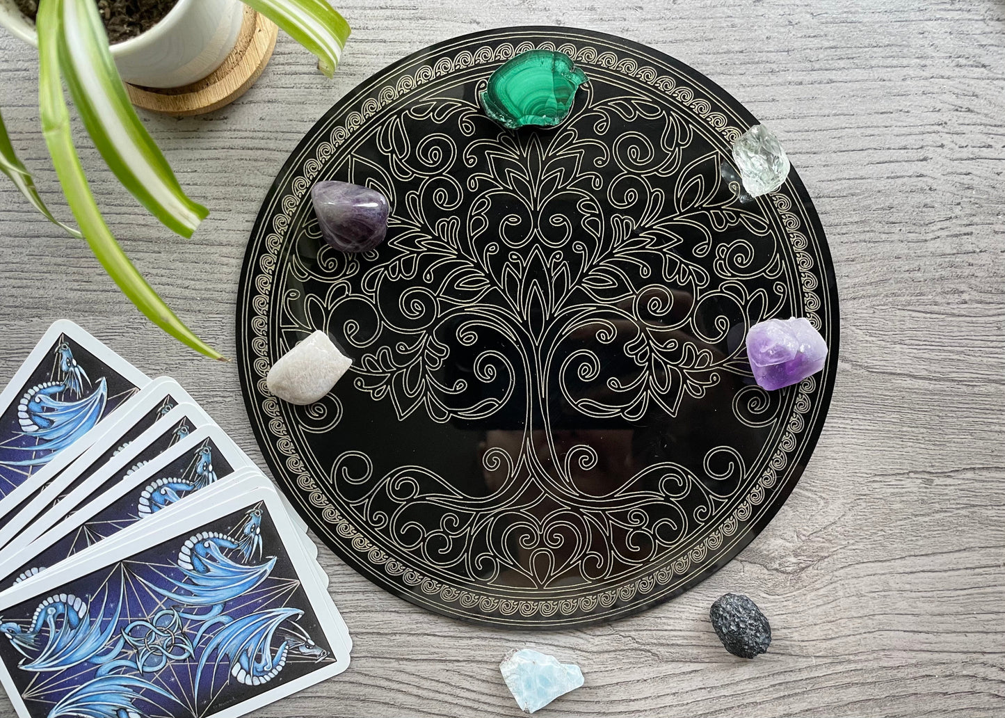 Pictured is a black acrylic crystal grid with a tree of life design.