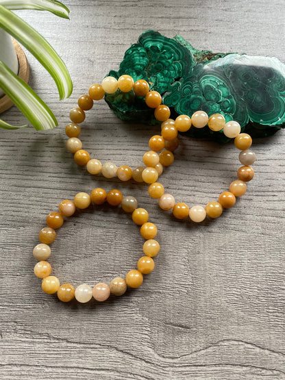 Pictured is a yellow jade bead bracelet.