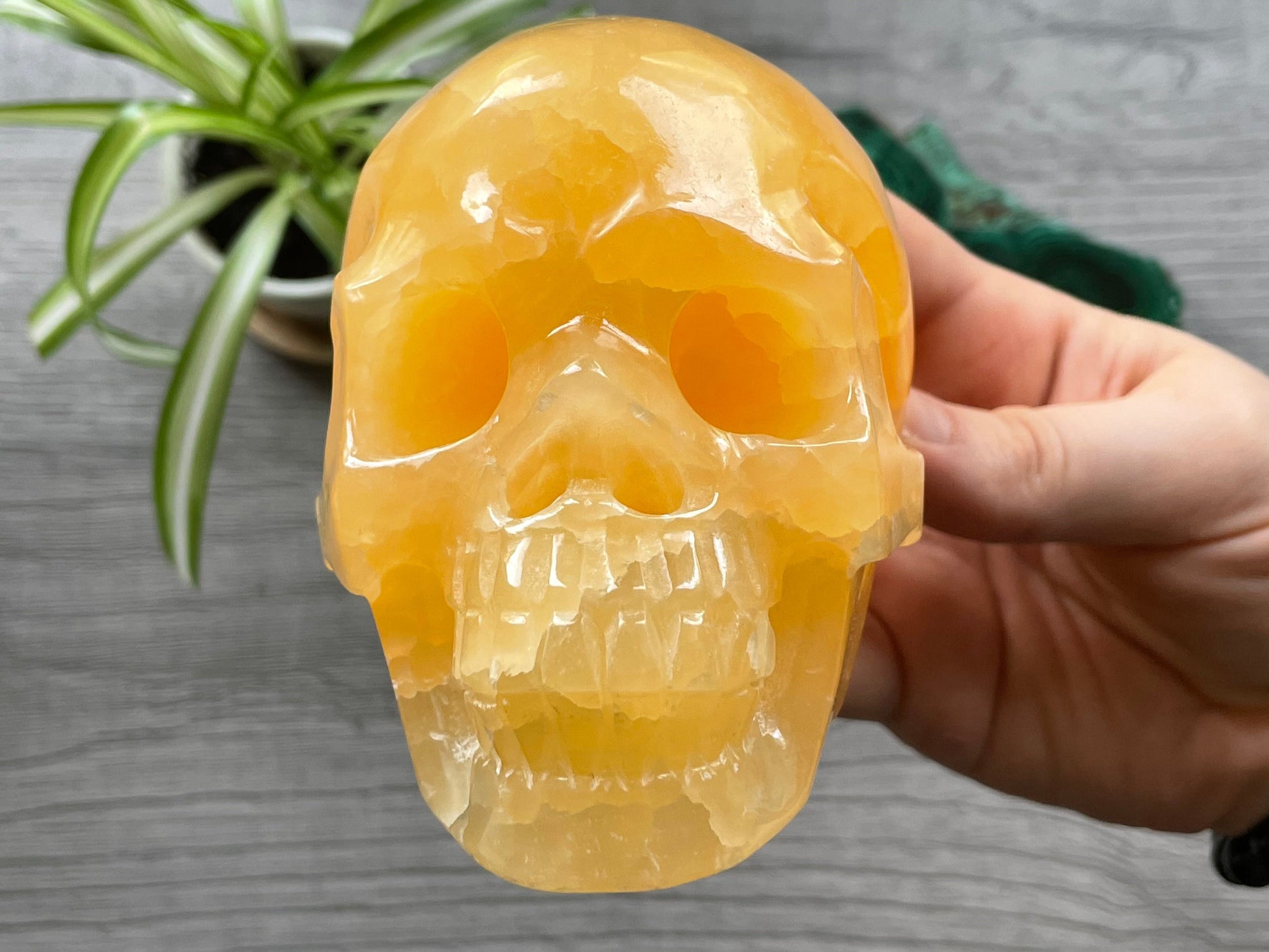 Pictured is a large skull carved out of orange calcite.