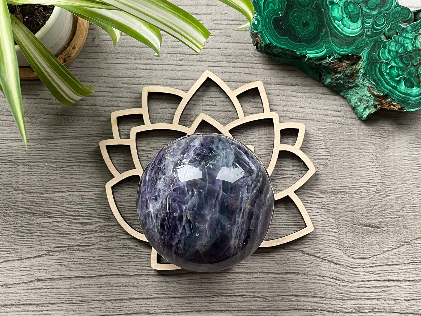 Pictured is a wood sphere stand in the shape of a lotus flower.