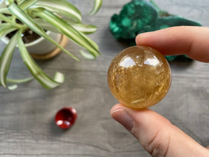 Pictured is a sphere carved out of honey calcite.