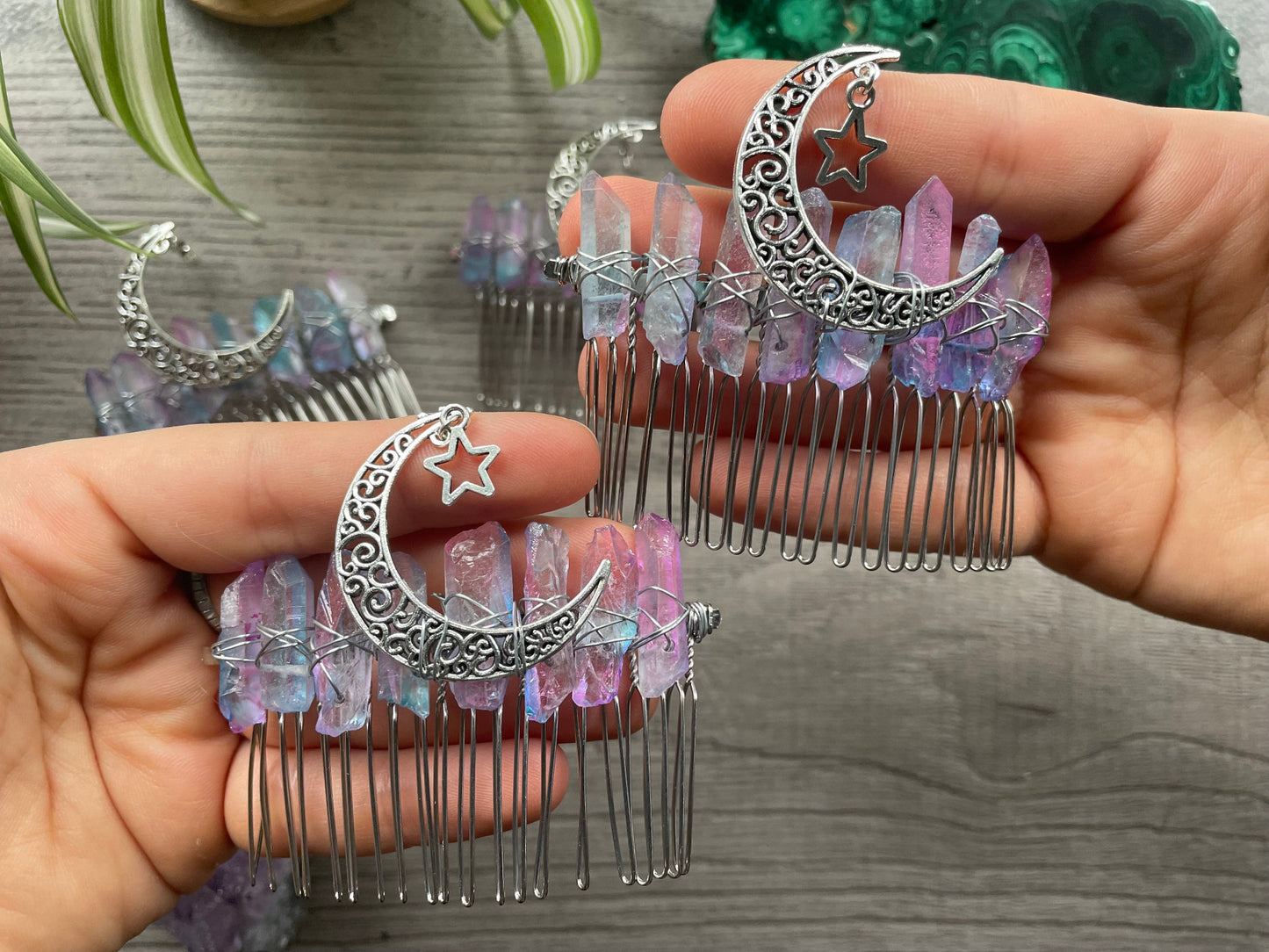 Pictured are various aura quartz hair combs with silver crescent moons on them.