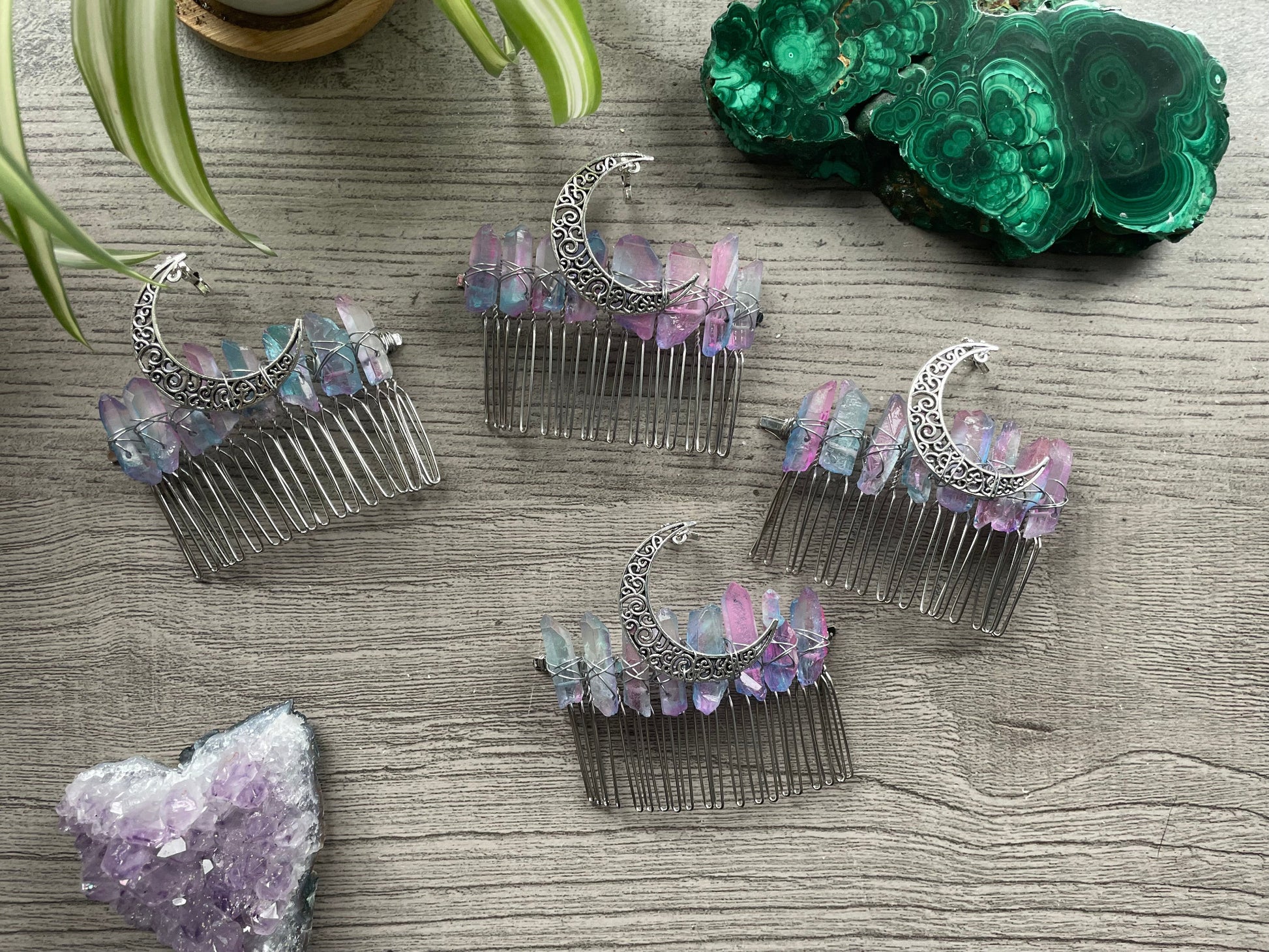 Pictured are various aura quartz hair combs with silver crescent moons on them.